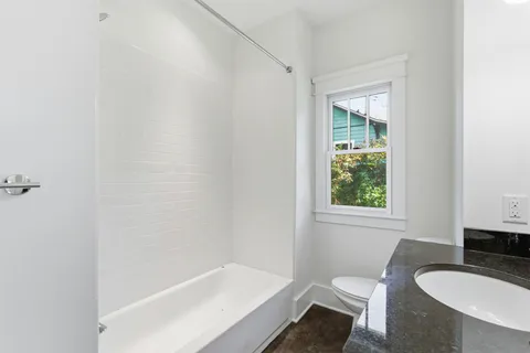 a bathroom with a granite countertop sink and a window