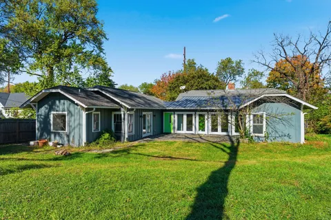 an aerial view of residential houses with outdoor space and trees