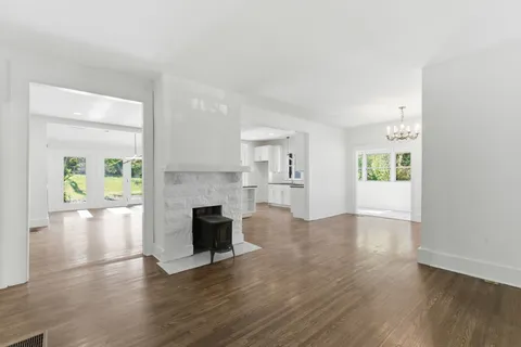 an empty room with wooden floor and outdoor kitchen