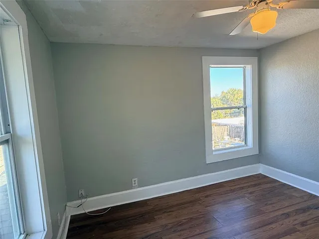 an empty room with wooden floor and a window