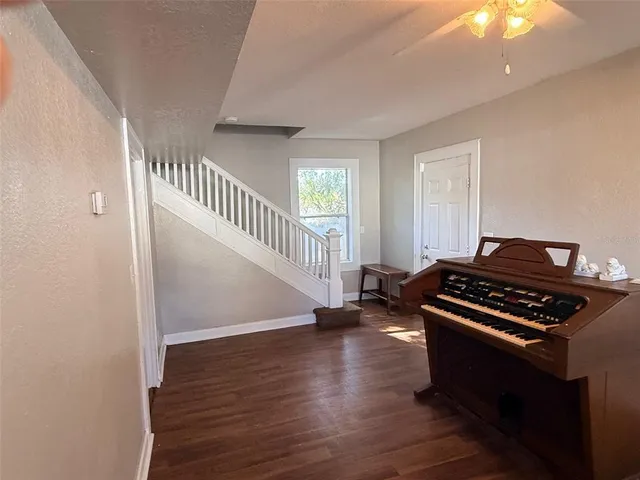 a view of a livingroom with wooden floor and stairs