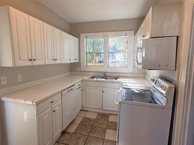 a kitchen with a sink cabinets and window