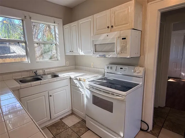 a kitchen with white cabinets and white appliances