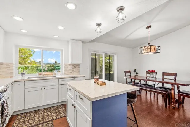 a kitchen with a stove a sink a dining table and chairs