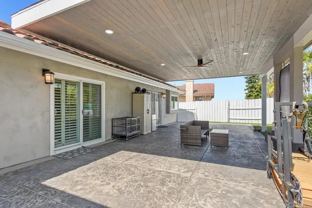 a view of a patio with table and chairs with wooden floor and fence