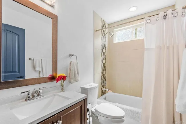 a bathroom with a sink vanity mirror and toilet