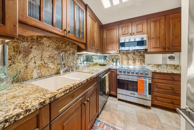a kitchen with stainless steel appliances granite countertop a stove and a refrigerator