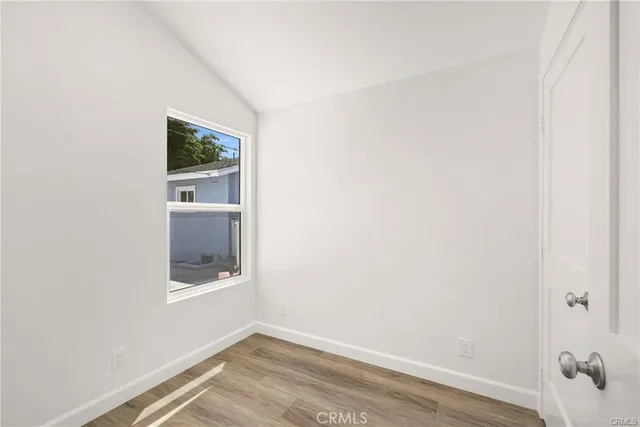 a view of a small space with wooden floor and a window