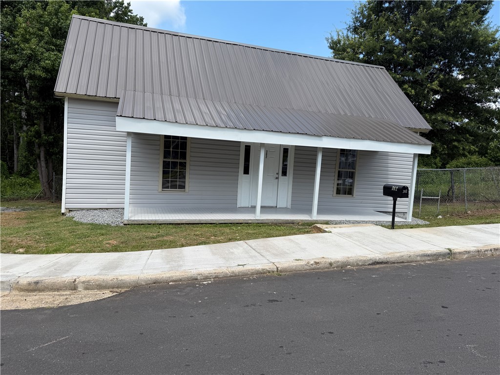 302 Sirrine Street Honea Path, SC 29654 - Photo 3 of 24 A charming cottage facade, complete with a welcoming front porch and a durable metal roof.