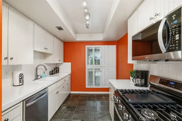 a kitchen with stainless steel appliances granite countertop a stove and a sink