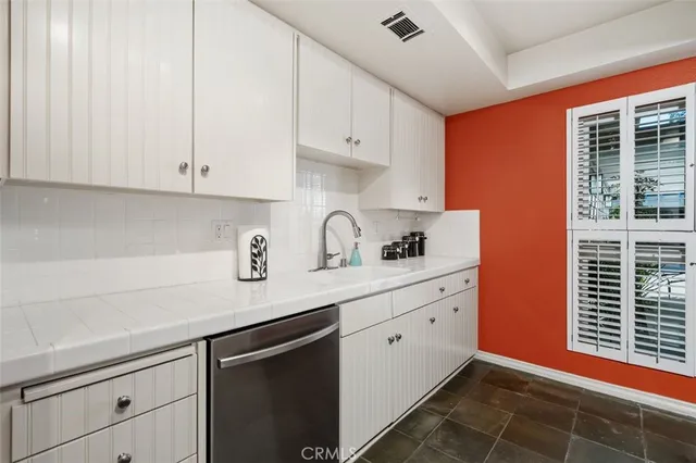 a kitchen with granite countertop white cabinets and white appliances