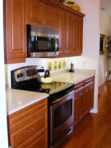 a kitchen with stainless steel appliances a stove a microwave a sink and cabinets