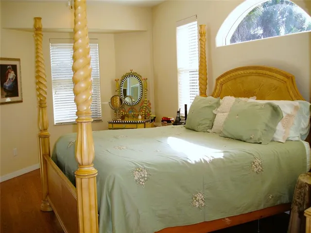 a bedroom with a bed and wooden floor