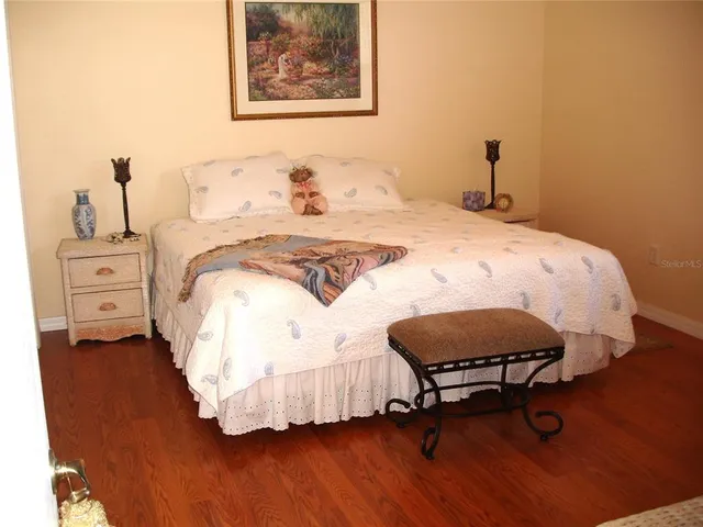 a bedroom with a bed and wooden floor