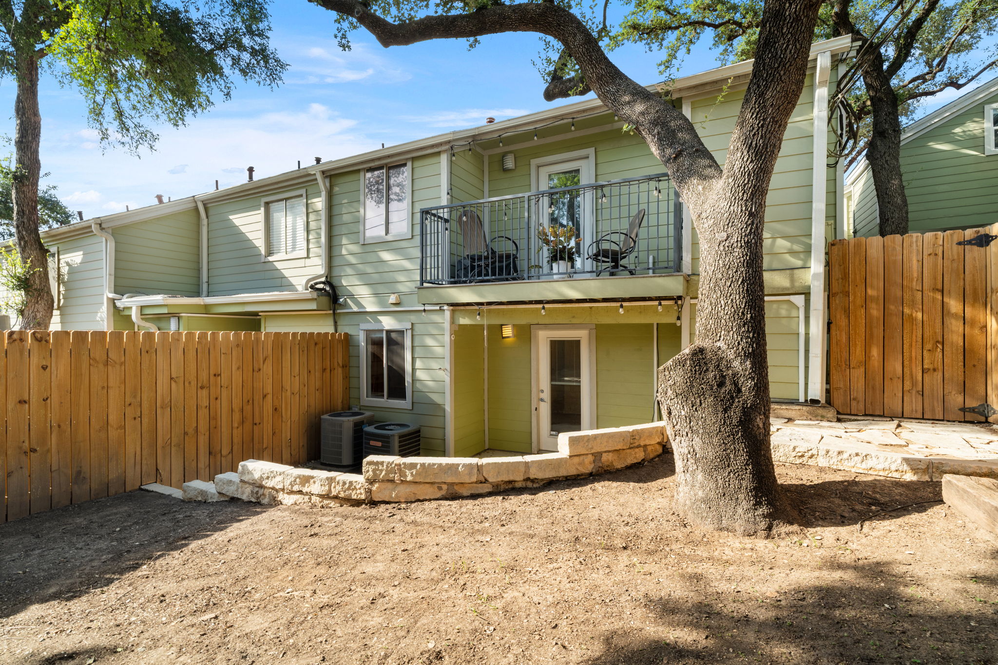 3601 Menchaca Road, Unit 110 Austin, TX 78704 - Photo 34 of 37 A quaint private yard with a stone retaining wall and a wood fence.