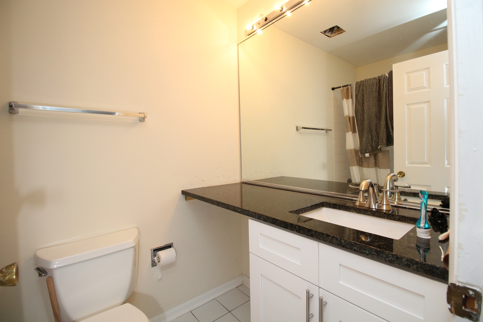 Undisclosed Address Chicago, IL 60657 - Photo 11 of 23 a bathroom with a granite countertop sink and a mirror