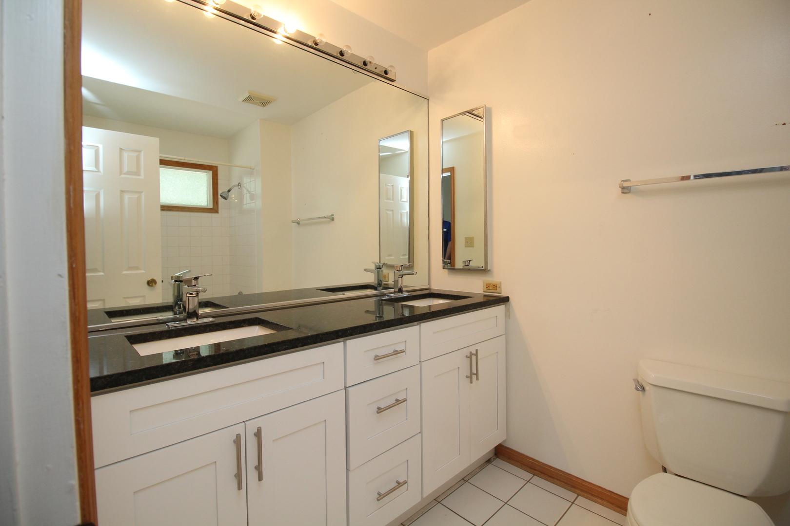 Undisclosed Address Chicago, IL 60657 - Photo 14 of 23 a bathroom with a granite countertop sink a toilet and a mirror