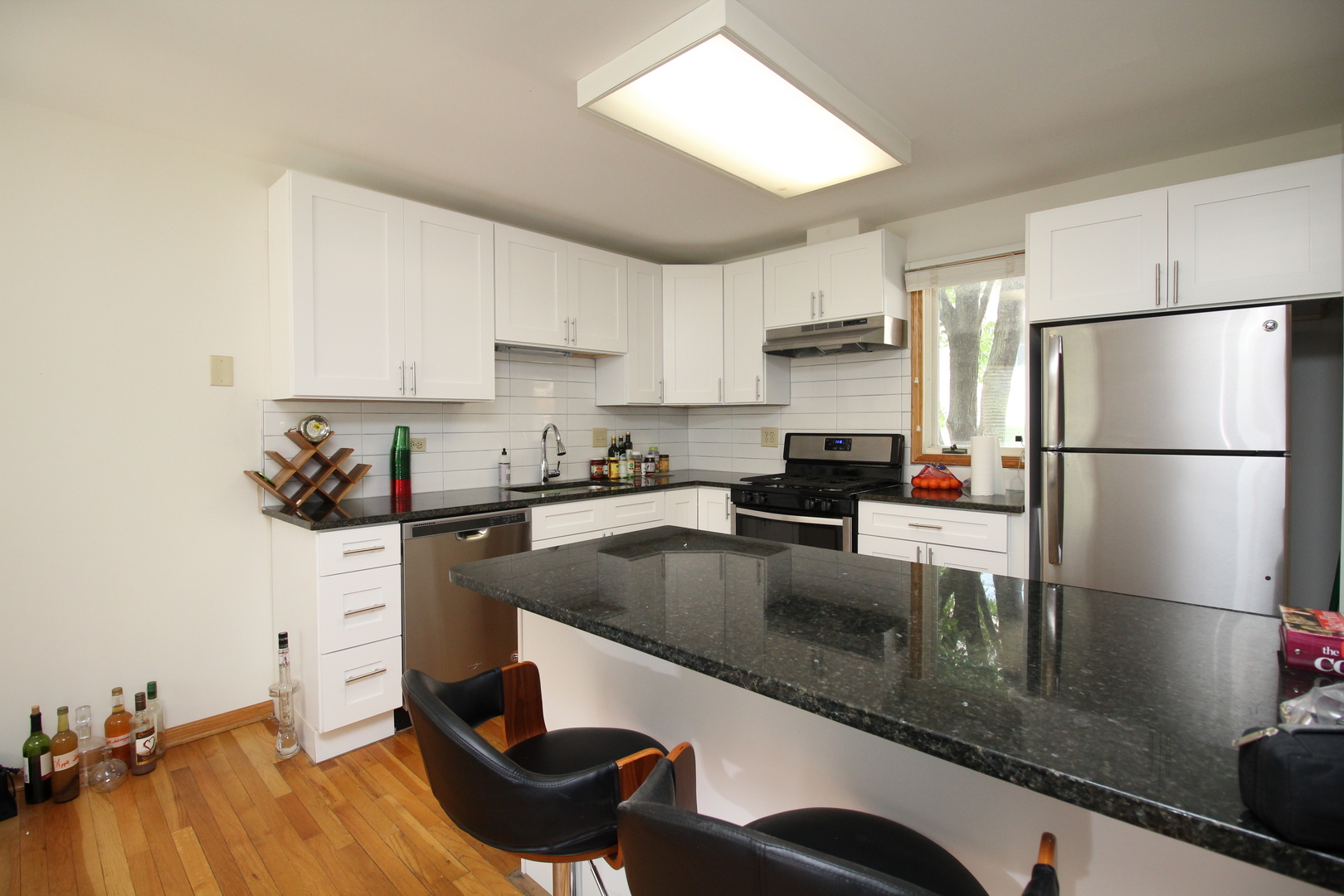 Undisclosed Address Chicago, IL 60657 - Photo 2 of 23 a kitchen with stainless steel appliances granite countertop a refrigerator a sink a stove and white cabinets