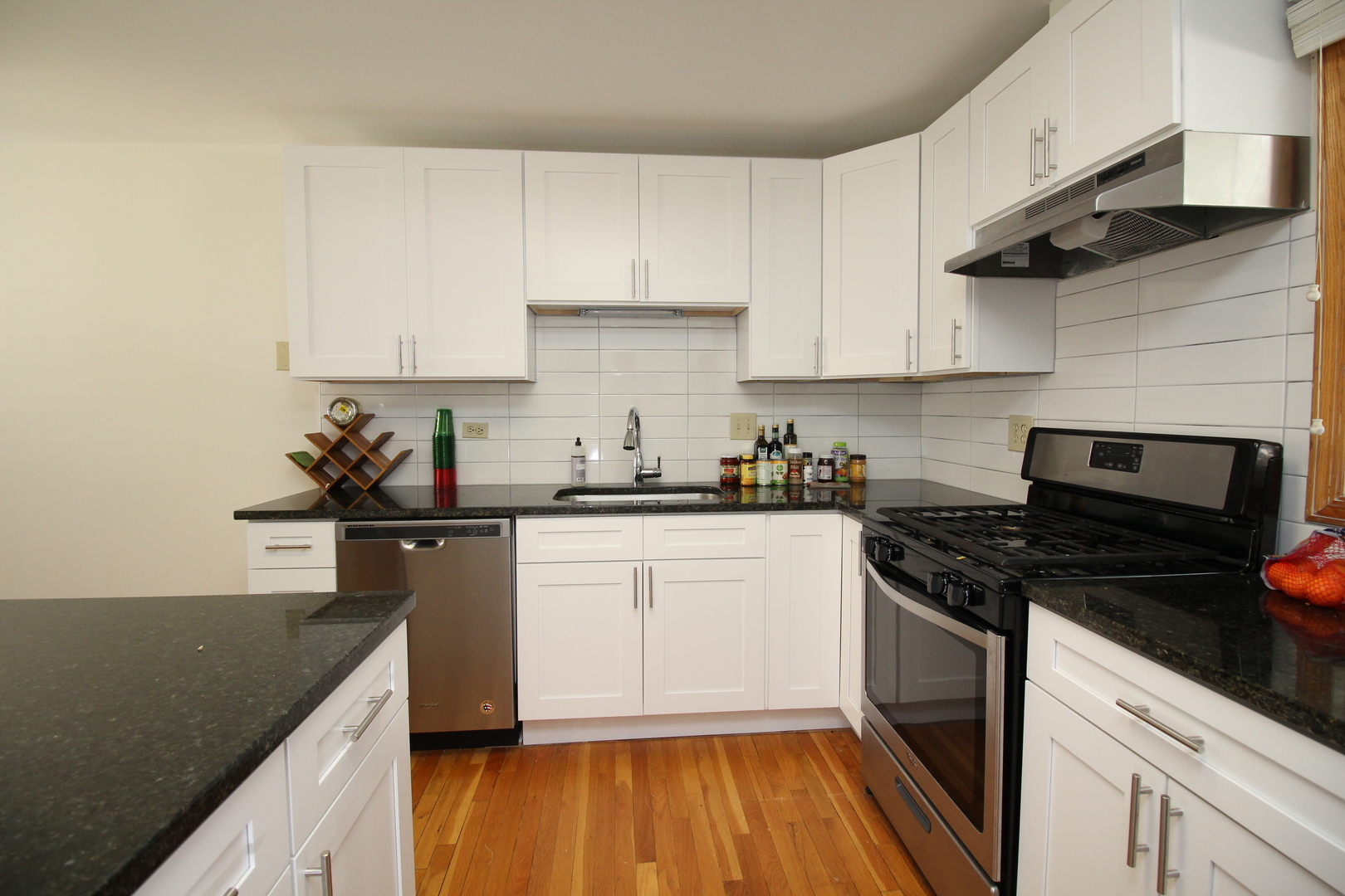 Undisclosed Address Chicago, IL 60657 - Photo 10 of 23 a kitchen with granite countertop a sink a stove and cabinets