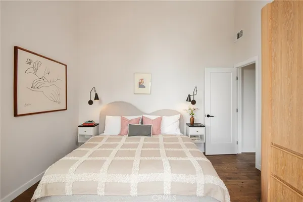 a bedroom with a large bed and a painting on the wall