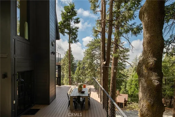 a view of a balcony dining table and chairs with wooden floor and fence