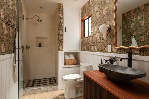 a bathroom with a granite countertop sink a toilet and shower