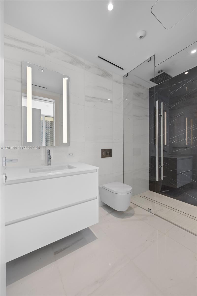 300 Biscayne Blvd Way, Unit 1102 Miami, FL 33131 - Photo 24 of 37 a bathroom with a white tub shower and a sink