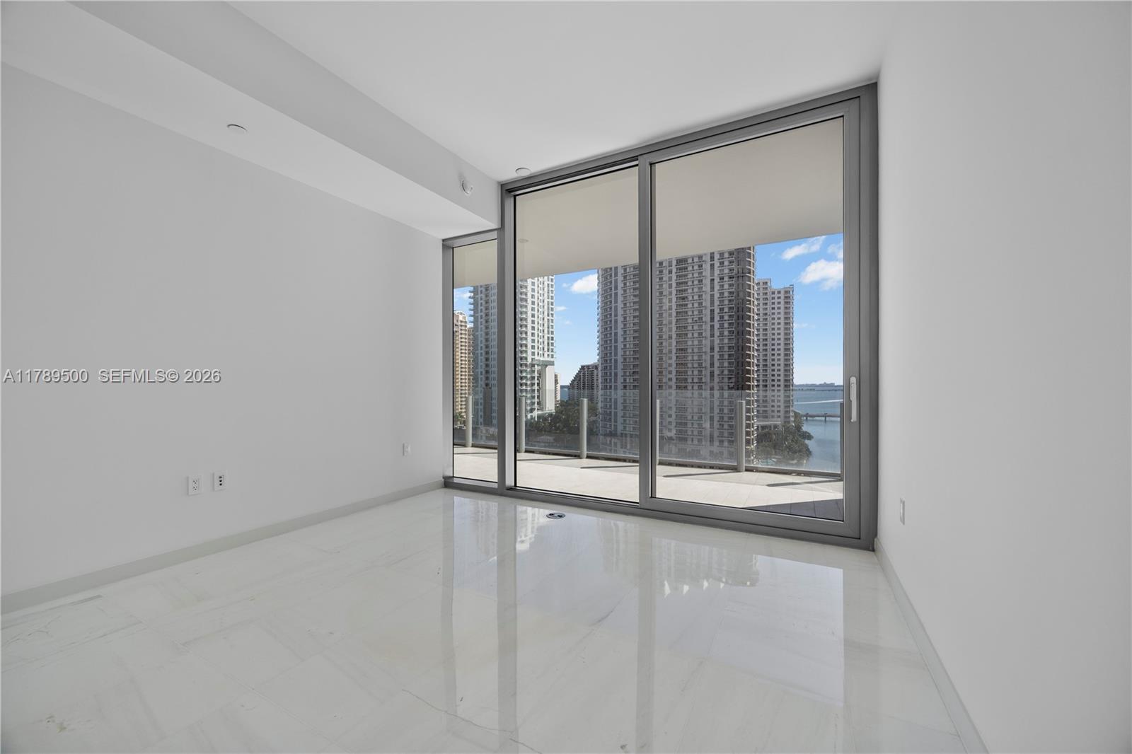 300 Biscayne Blvd Way, Unit 1102 Miami, FL 33131 - Photo 32 of 37 a view of an empty room with sliding glass door
