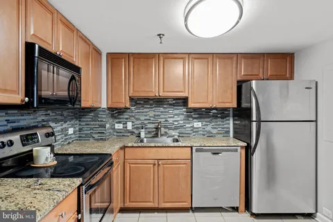 a kitchen with stainless steel appliances granite countertop a stove microwave and cabinets