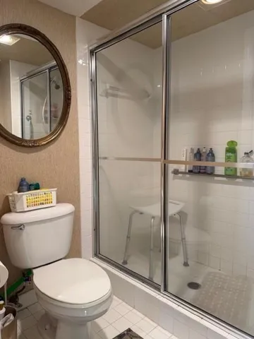 a bathroom with a glass shower door and a mirror
