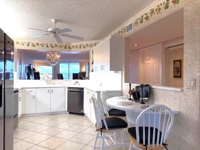 a kitchen with a dining table chairs and white cabinets