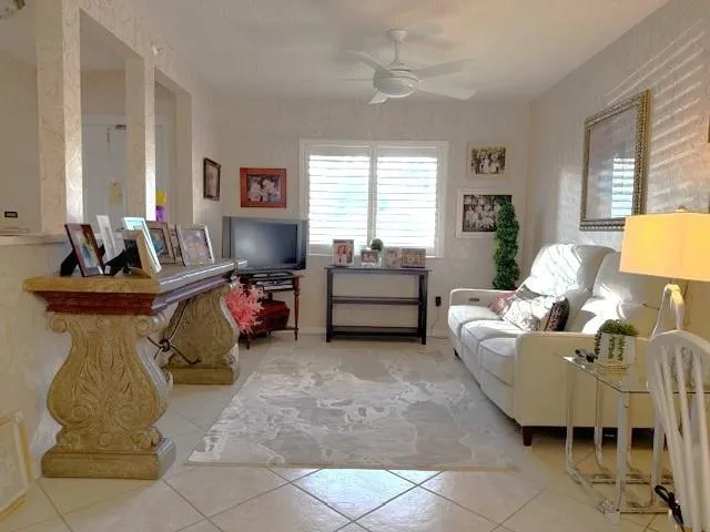 a view of a hallway with wooden floor and a living room