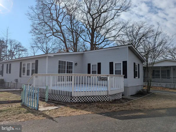 a view of a house with a wooden fence and a bench