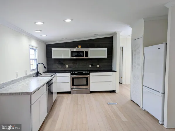 a kitchen with stainless steel appliances a stove a sink and a refrigerator