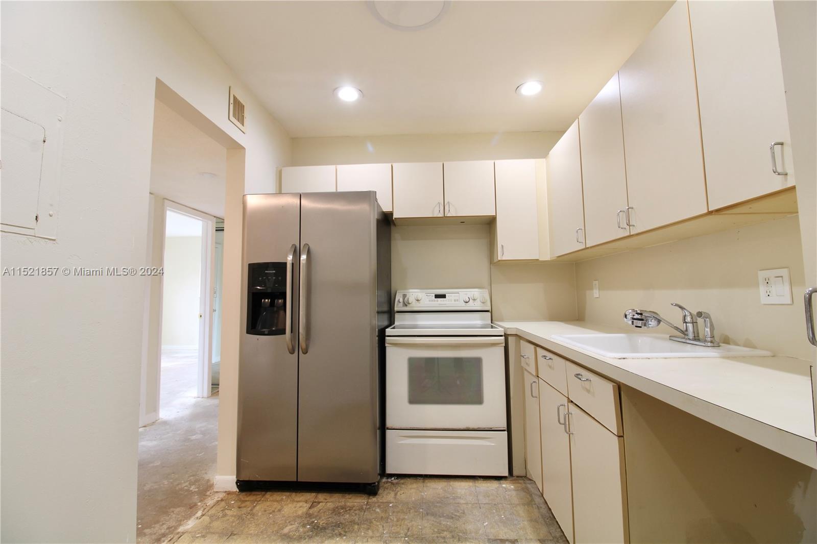 9015 Southwest 138th Street, Unit 162 Miami, FL 33176 - Photo 7 of 16 a kitchen with a sink a refrigerator and cabinets