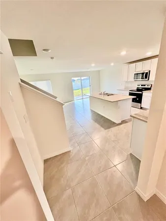 a view of kitchen with furniture and electronic appliances