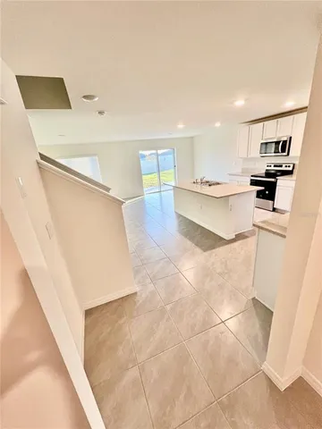 a view of kitchen with furniture and electronic appliances