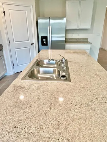 a kitchen with granite countertop a sink and a refrigerator
