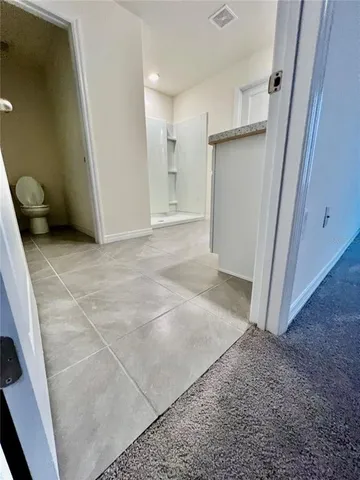 a view of a hallway with closet and wooden door