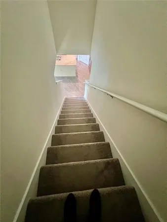 a view of a livingroom with wooden floor and stairs
