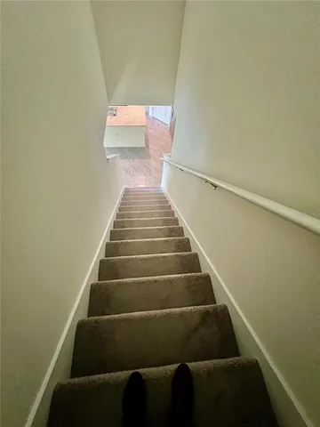 a view of a livingroom with wooden floor and stairs