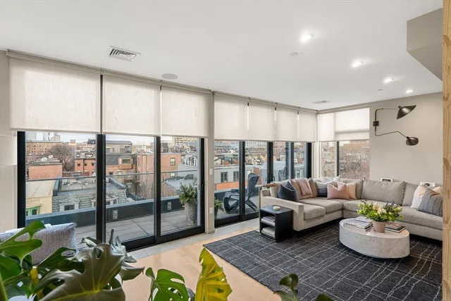 a living room with furniture and a floor to ceiling window