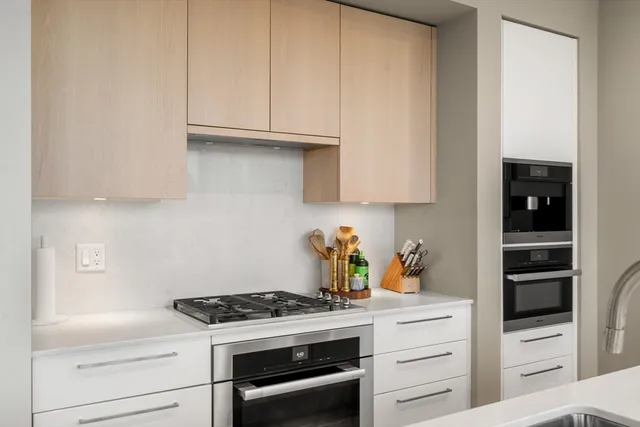 a kitchen with white cabinets and appliances