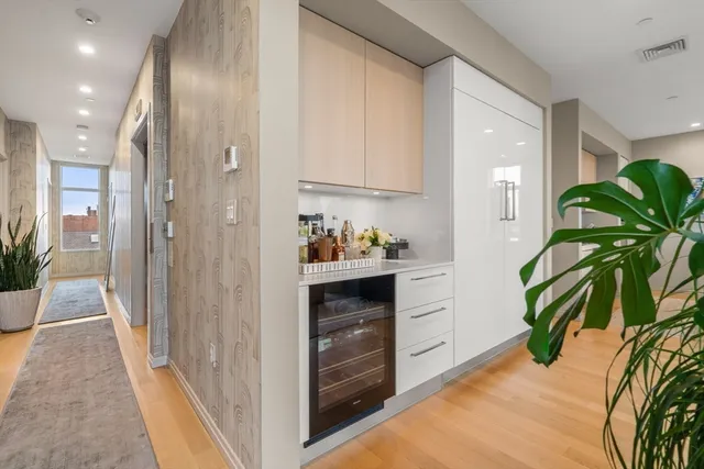 a hallway with white cabinets and wooden floor