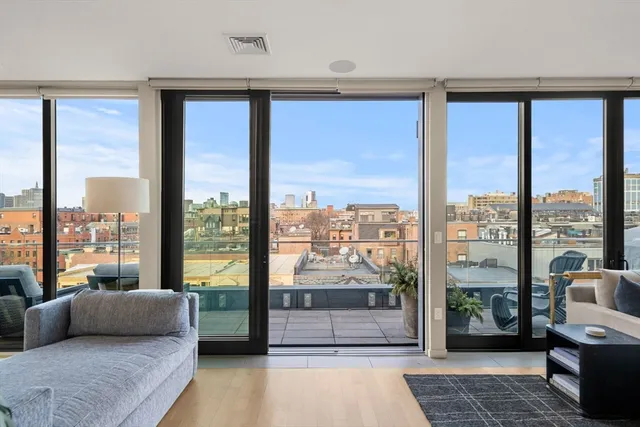 a living room with furniture and a floor to ceiling window