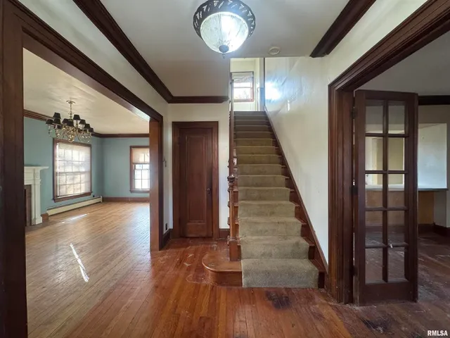 a view of a hallway with wooden floor and staircase