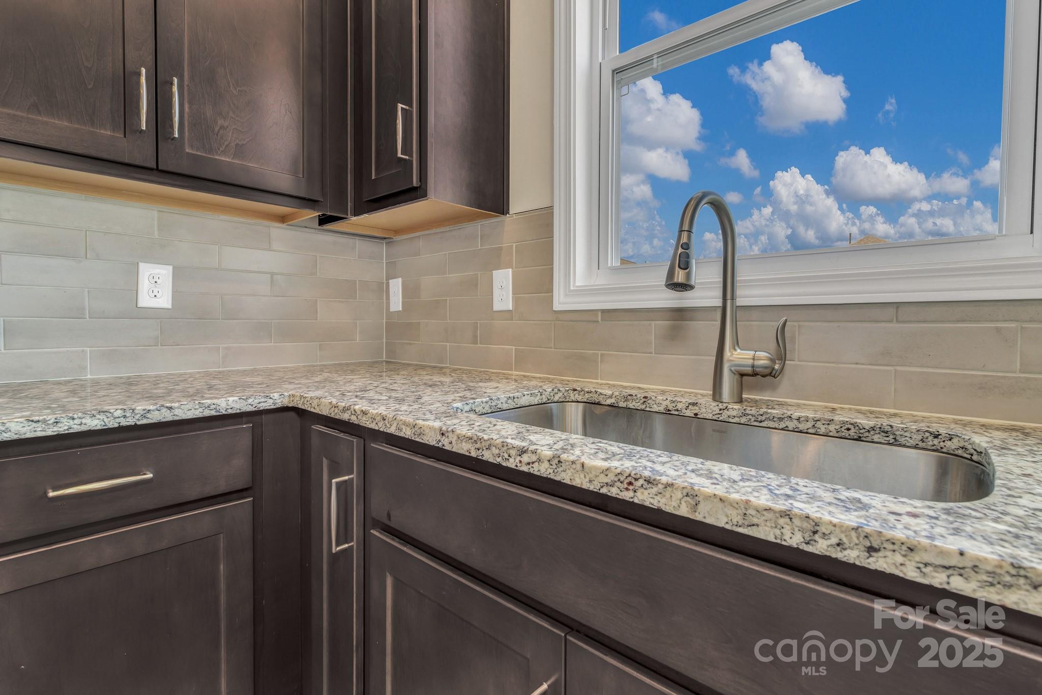 59 Thornberry Road Hendersonville, NC 28792 - Photo 19 of 48 a kitchen with granite countertop a sink and cabinets