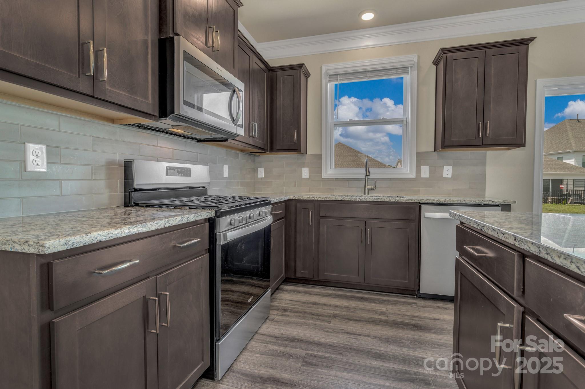 59 Thornberry Road Hendersonville, NC 28792 - Photo 21 of 48 a kitchen with stainless steel appliances granite countertop a sink stove and cabinets