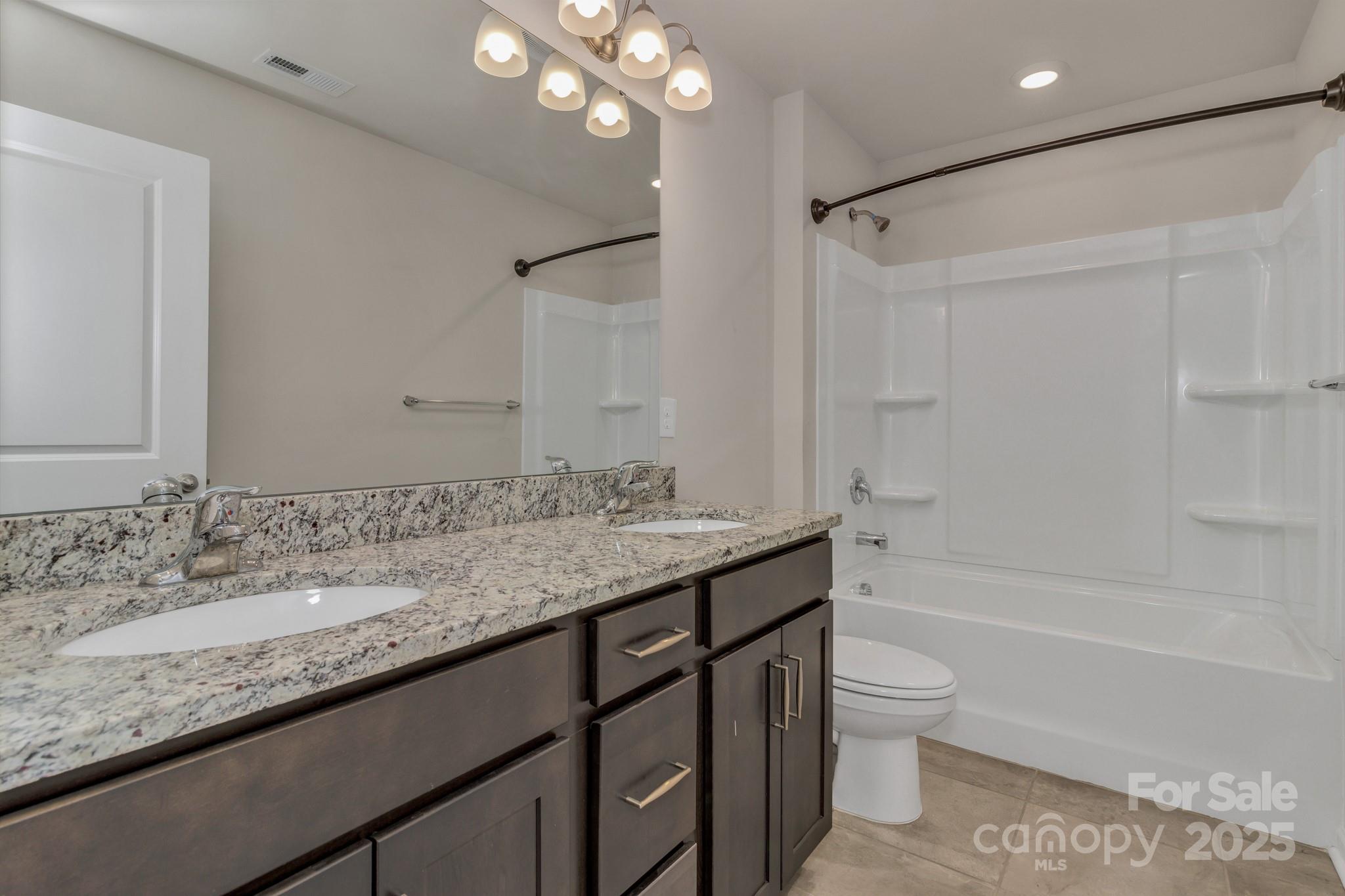 59 Thornberry Road Hendersonville, NC 28792 - Photo 37 of 48 a bathroom with a granite countertop sink a toilet and shower