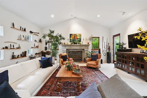 a living room with furniture fireplace and a large window